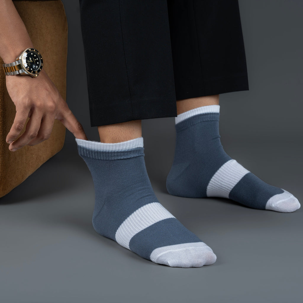 Person wearing blue and white striped bamboo socks on a gray background