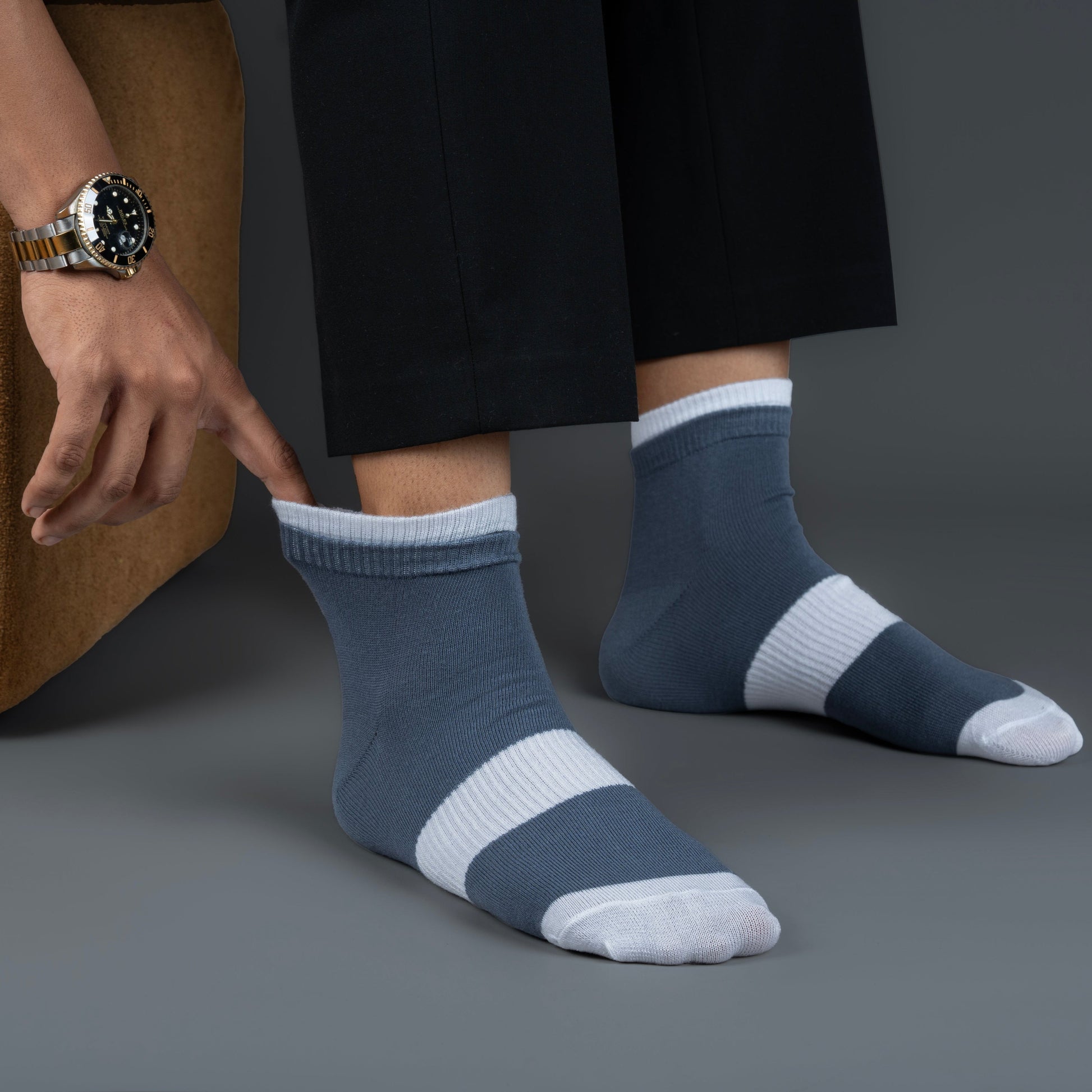 Person wearing blue and white striped bamboo socks on a gray background