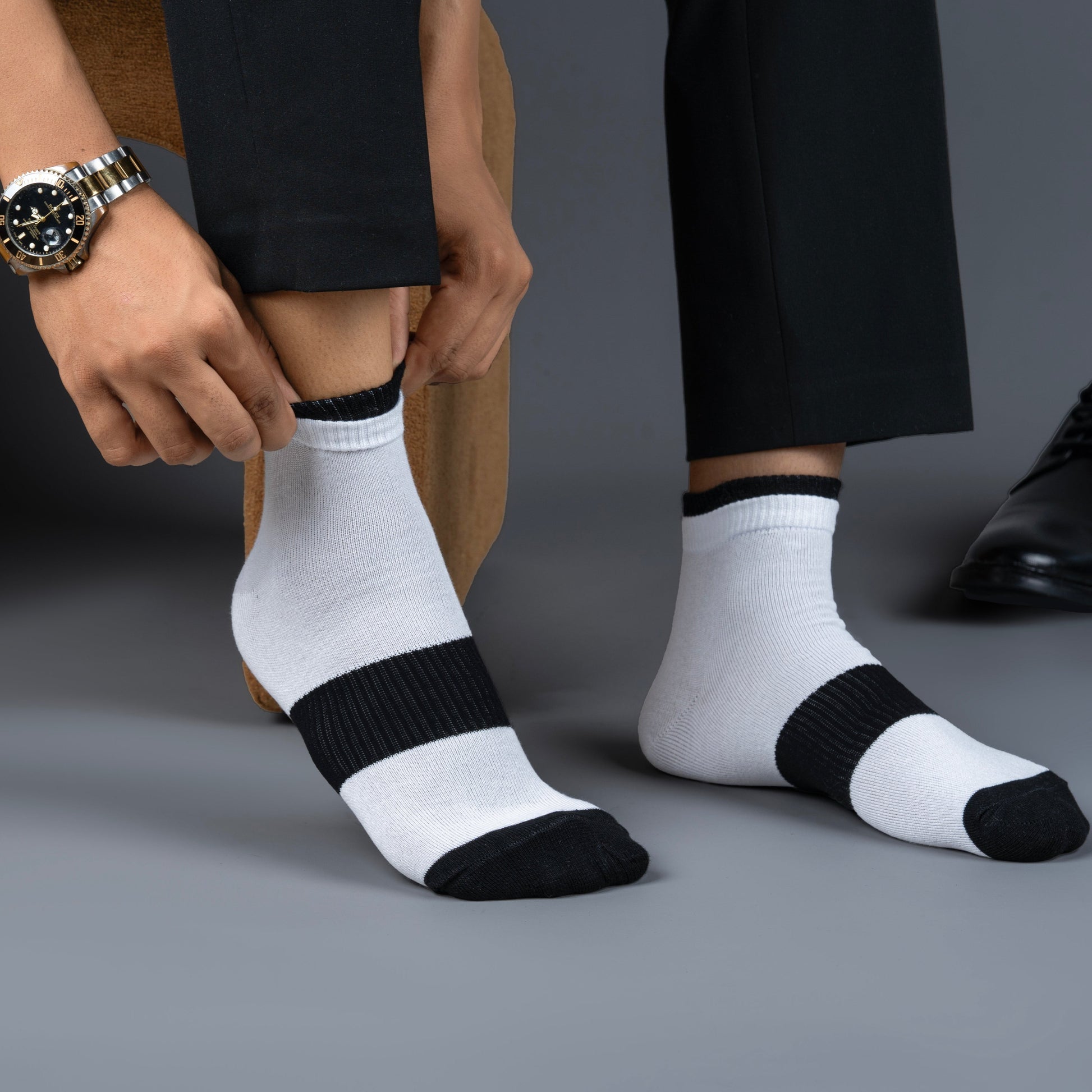 Person wearing white bamboo socks with black accents on a gray background
