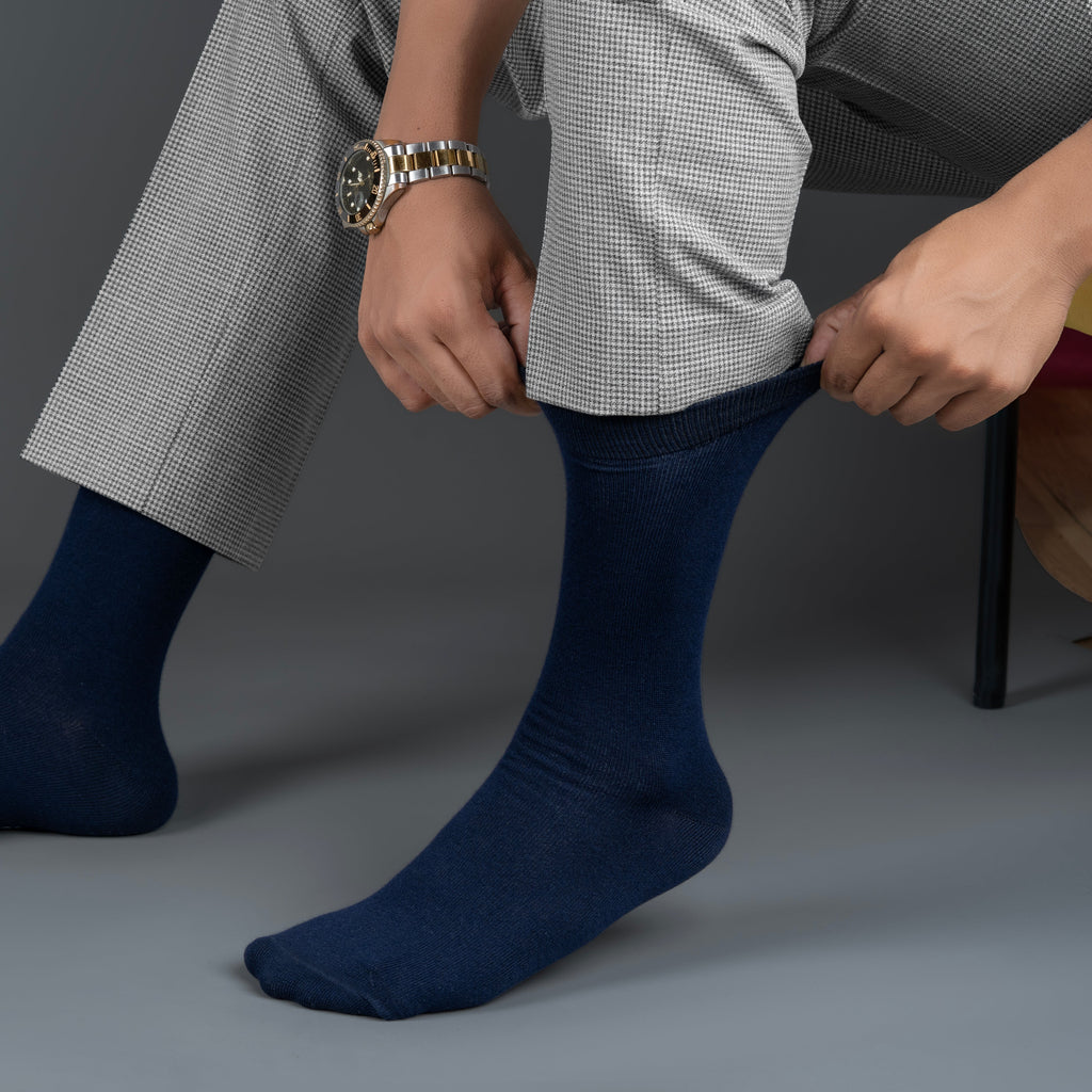 Person wearing navy blue bamboo socks with a gray background