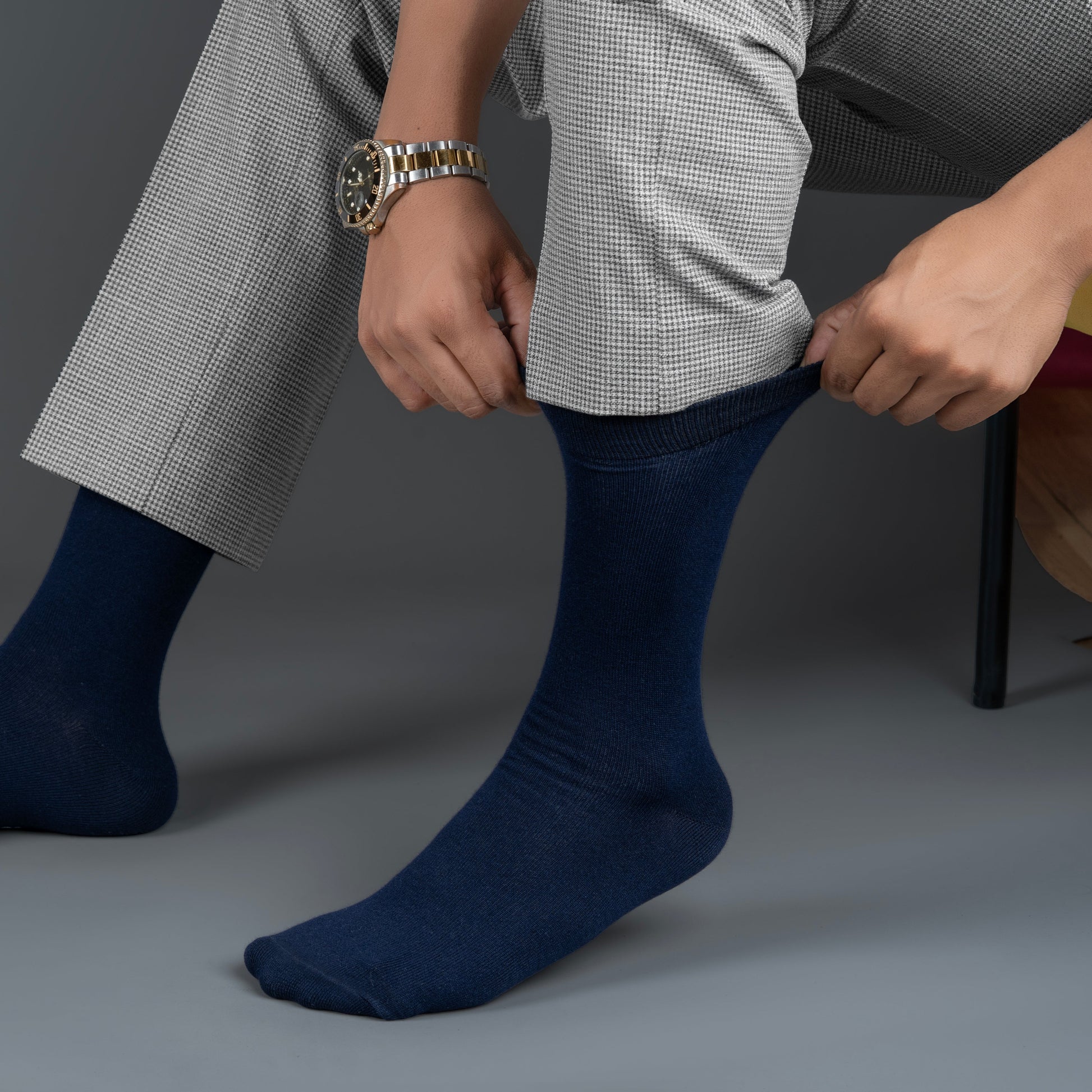 Person wearing navy blue bamboo socks with a gray background