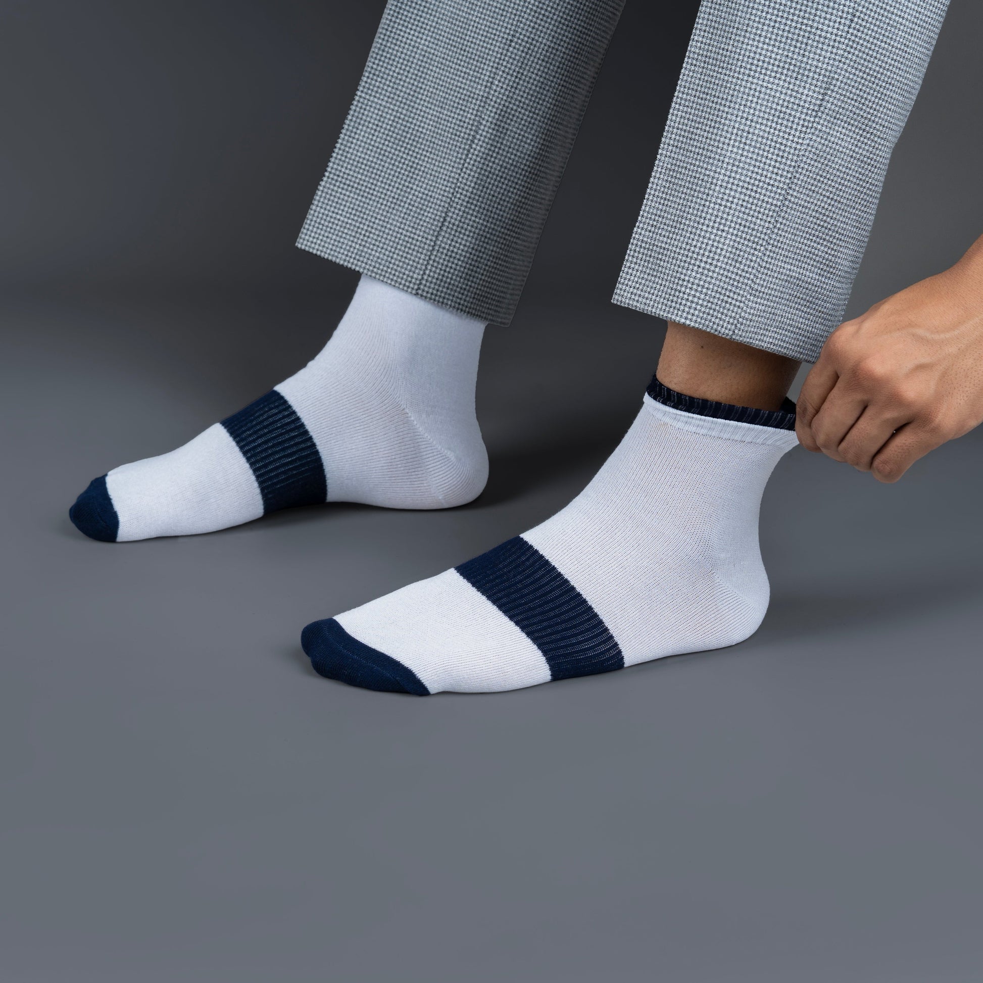 White bamboo socks with navy stripes worn by a person on a gray background