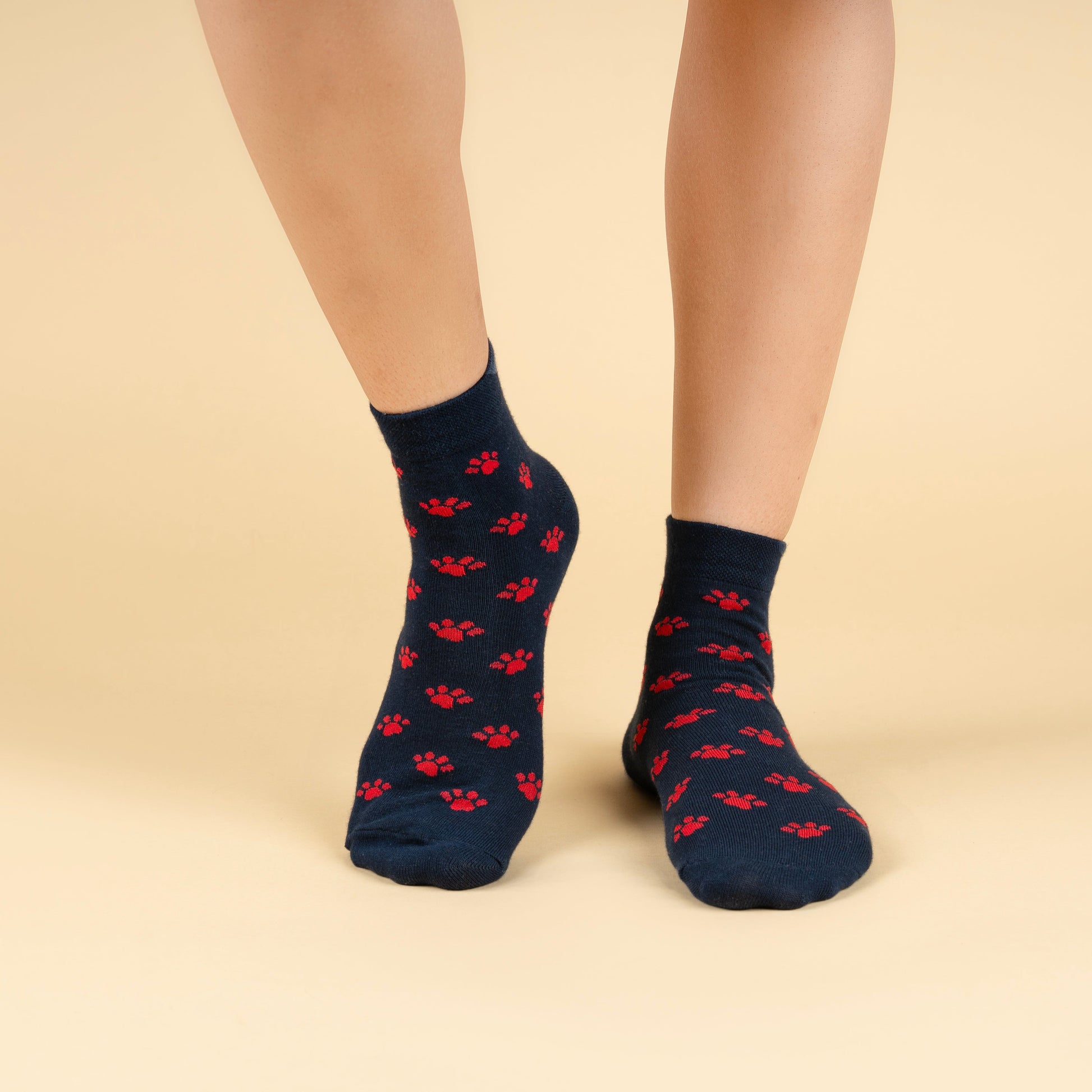 Navy socks with red patterns worn by a person on a beige background