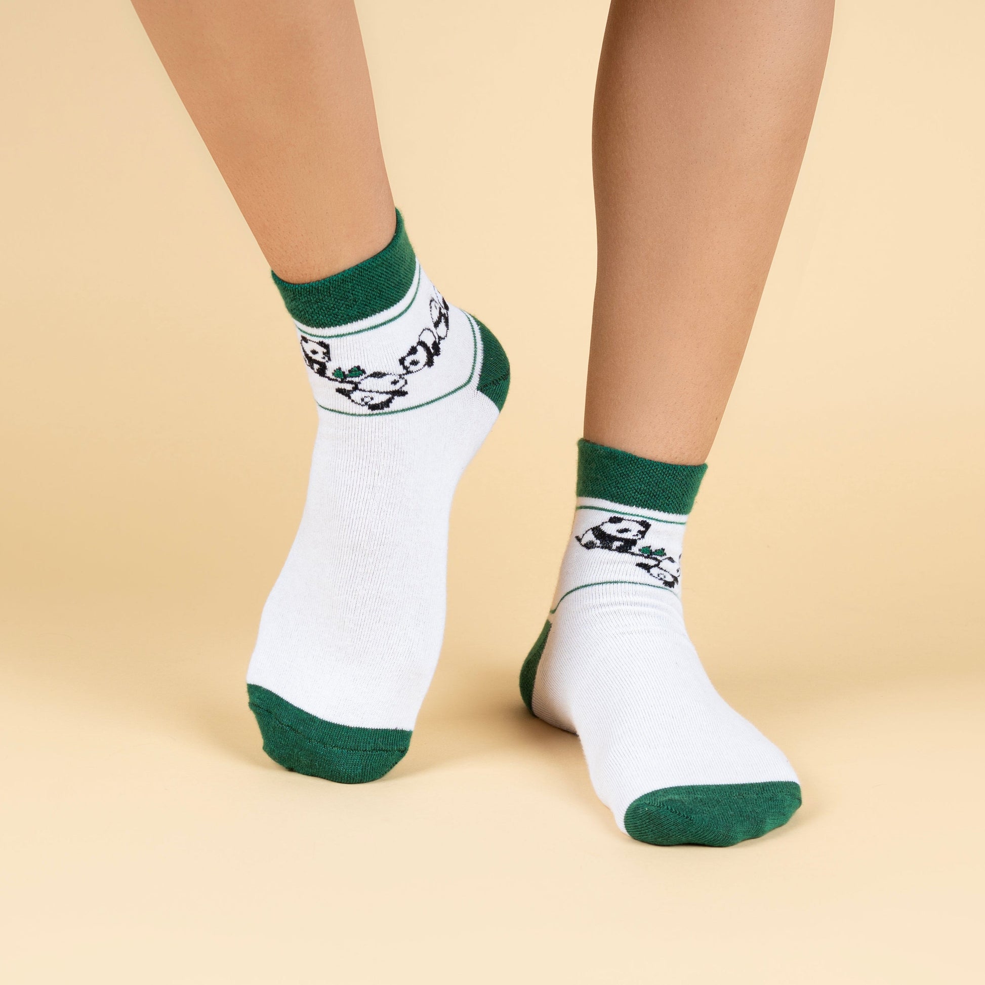 White socks with green accents worn by a person on a beige background
